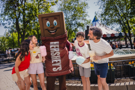 Family gathered for photo-op with Hersheypark Character, Hershey's inside of Hersheypark.