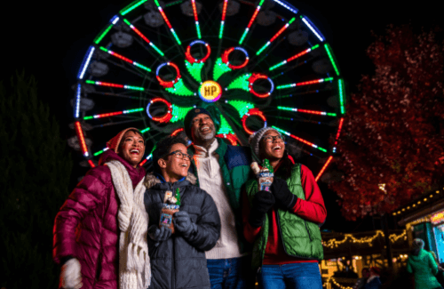 Family enjoying time at Hersheypark in front of Ferris wheel