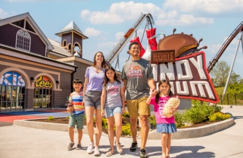 Happy family in front of Candymonium sign at Hersheypark
