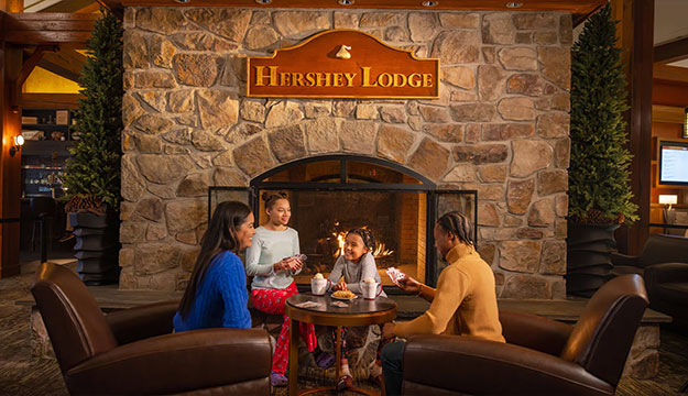 Family sitting at The Lodge by the fireplace