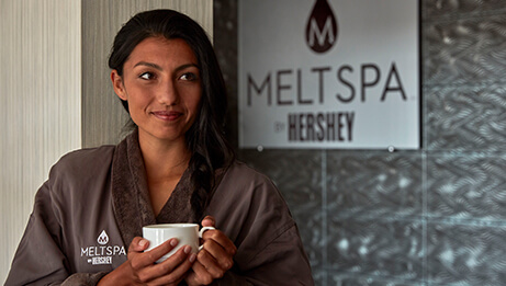 Woman standing in front of Meltspa sign
